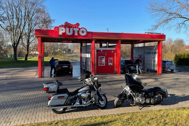 Two motorcycles parked in front of PUTO self-service car wash.