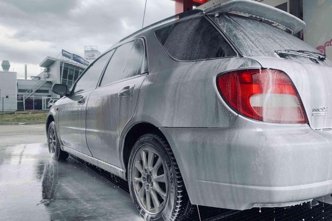 Car being washed with foam at PUTO self-service car wash, highlighting the advantages of washing.