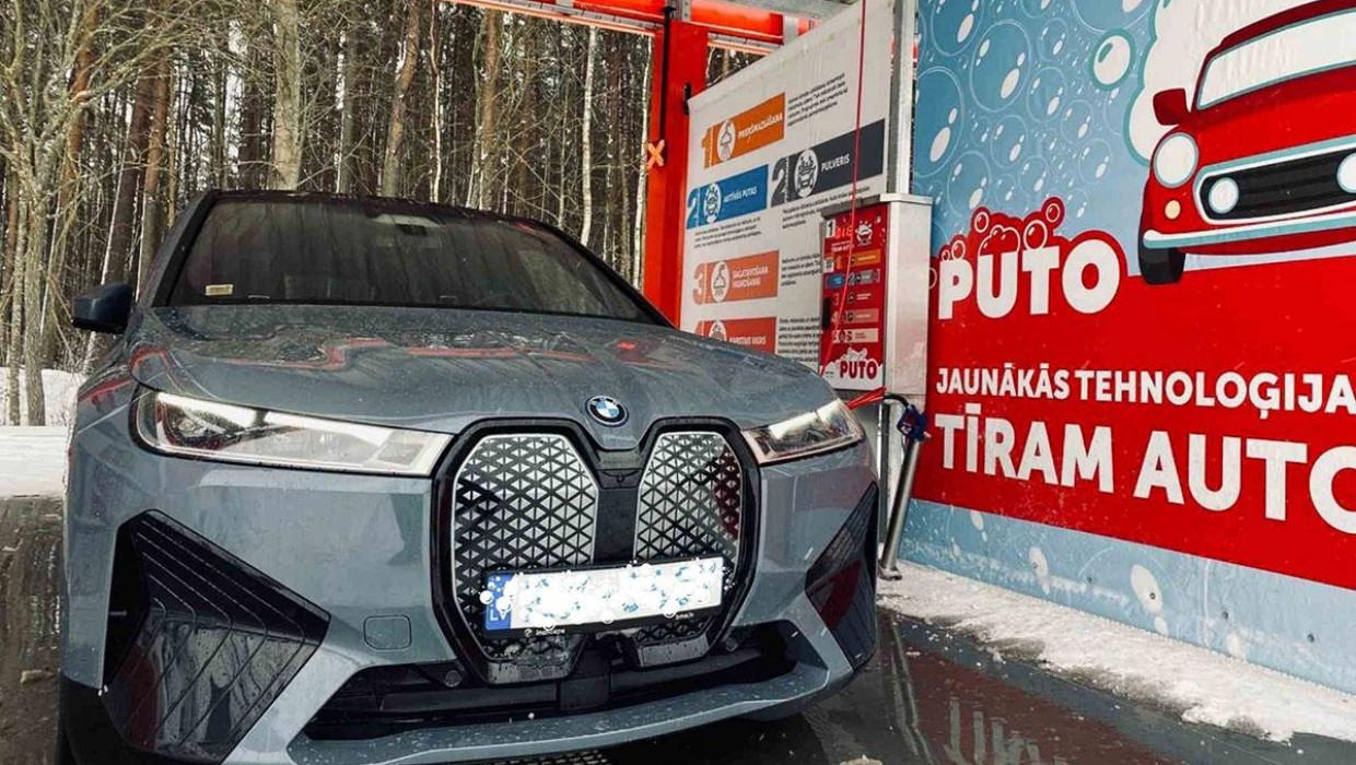 Electric car being washed at PUTO self-service car wash, using active foam technologies.