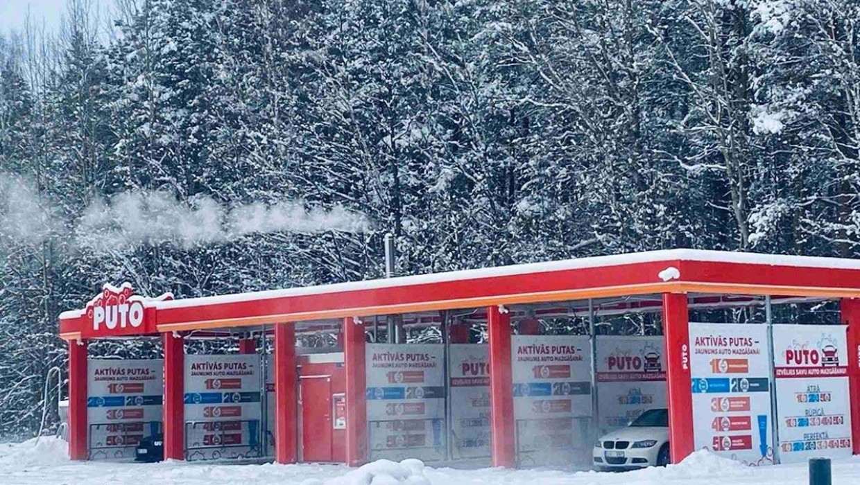 PUTO self-service car wash in Babīte during winter, with snow and a forest background.