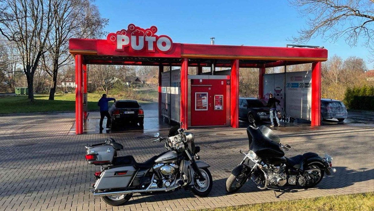 Two motorcycles parked in front of PUTO self-service car wash.
