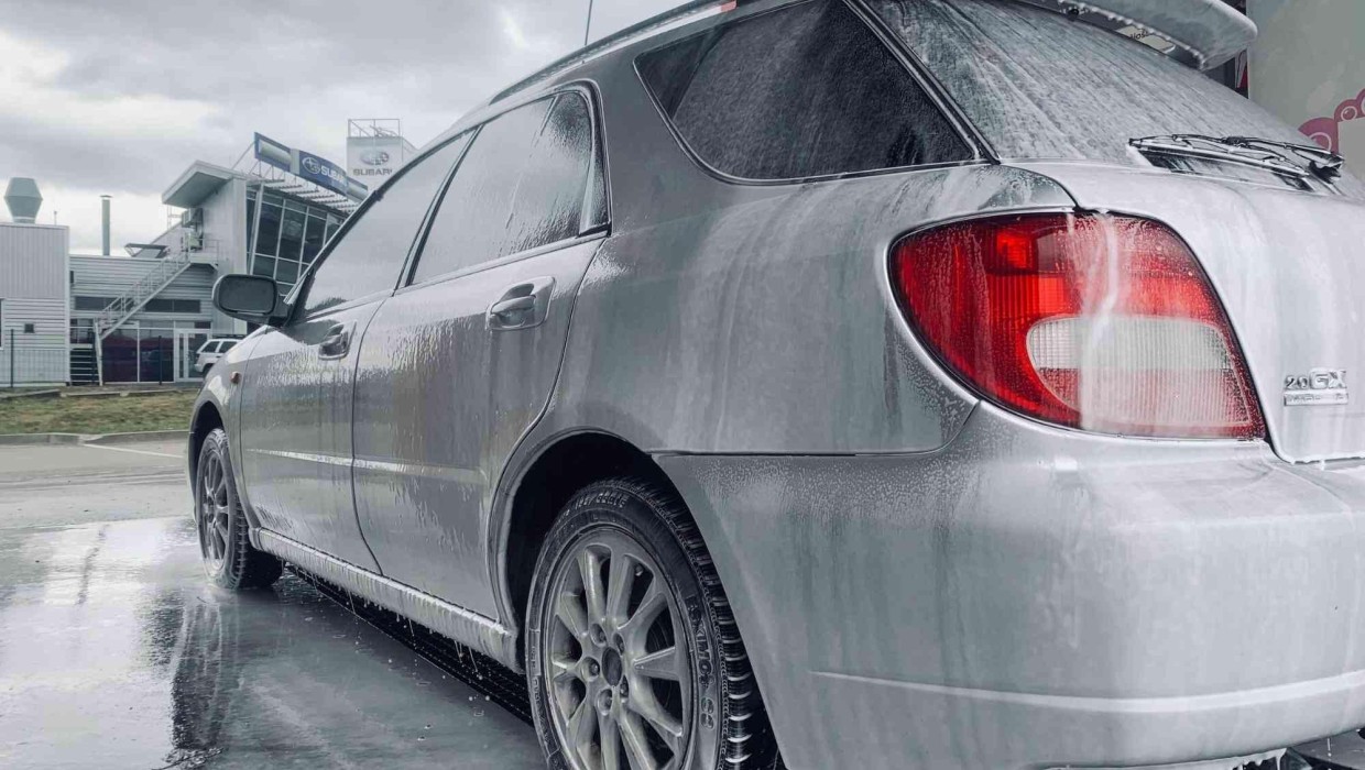 Car being washed with foam at PUTO self-service car wash, highlighting the advantages of washing.